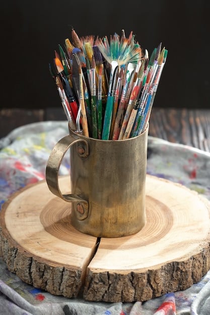 A close-up shot of a table with various art supplies - paintbrushes, colored pencils, paper, and clay - arranged neatly. A book is open nearby, suggesting a creative activity inspired by the reading material.