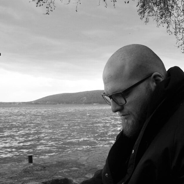 A black and white image of Sigmund Freud, gazing thoughtfully into the distance. The style is reminiscent of classic psychoanalytic portraits.