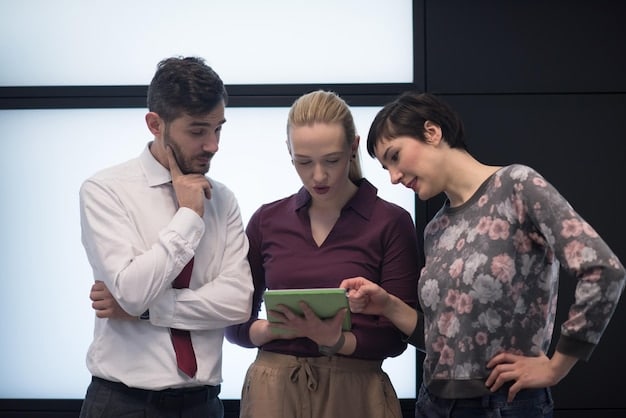 A group of theater directors and producers huddled around a table, looking at data analytics on a laptop screen. The data represents audience sentiment and online review scores for their latest production.