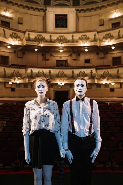 Two actors portraying characters from a well-known novel are on stage, engaged in a tense scene during a theatrical adaptation. Their costumes reflect the period of the novel.