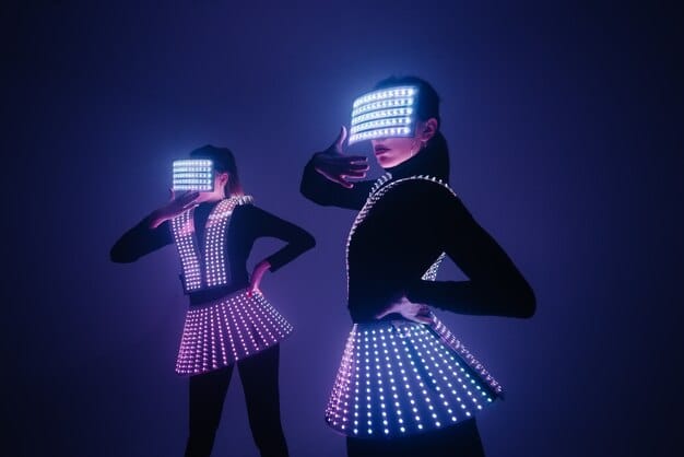 A vibrant stage scene with actors in colorful costumes interacting with holographic projections and augmented reality elements. The scene conveys a sense of futuristic technology integrated seamlessly with live performance.