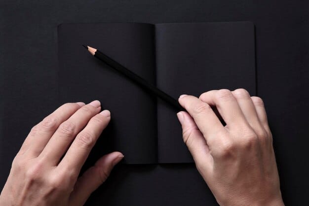 A close-up shot of a theater critic's hand holding a pen over a notepad in a dimly lit theater. The focus is on the act of writing and capturing impressions, with the surrounding theatrical environment blurred to emphasize the critic's perspective.