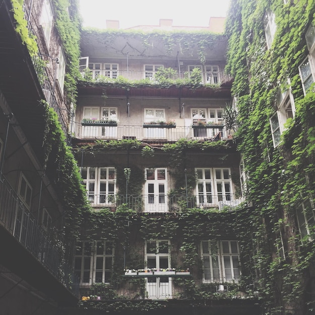 A split image contrasting a luxurious mansion with a crowded, run-down apartment building. This juxtaposition visually represents the economic disparity and challenges the notion that the American Dream is equally accessible to all, a core theme when 'Deconstructing the American Dream: A Marxist Literary Criticism Analysis of Contemporary American Plays'.