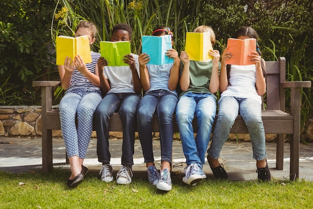 A photograph featuring diverse people reading books in a public space, such as a park or library. The image aims to convey the idea of literature as a shared cultural experience and the importance of inclusivity in literary analysis.