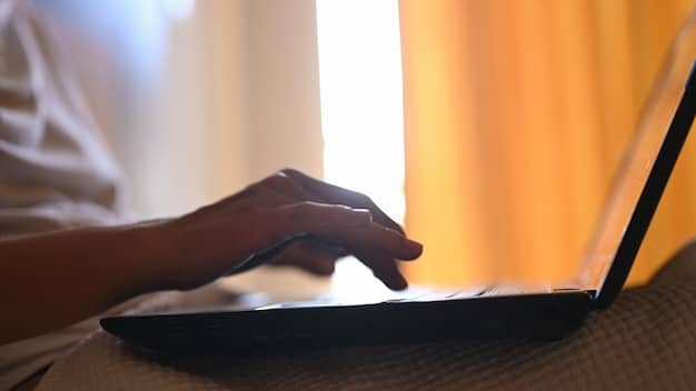 A person's hands typing on a laptop keyboard in a brightly lit room. The screen displays a website with a book review article, complete with headings, paragraphs, and images. The keyboard is clean and modern, and the room is organized and inviting, suggesting focus and productivity essential for book reviewing for beginners: a step-by-step guide to writing compelling critiques.
