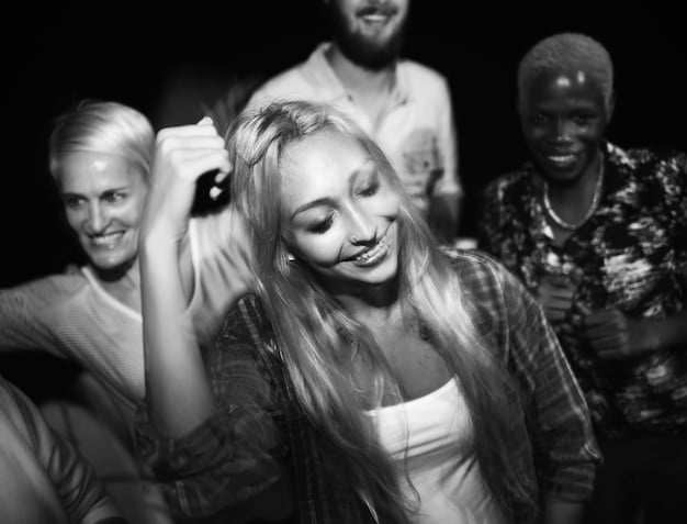 A black and white photo of a group of understudies, their faces showing camaraderie, backstage after a successful performance. The photo captures their sense of accomplishment and mutual support.
