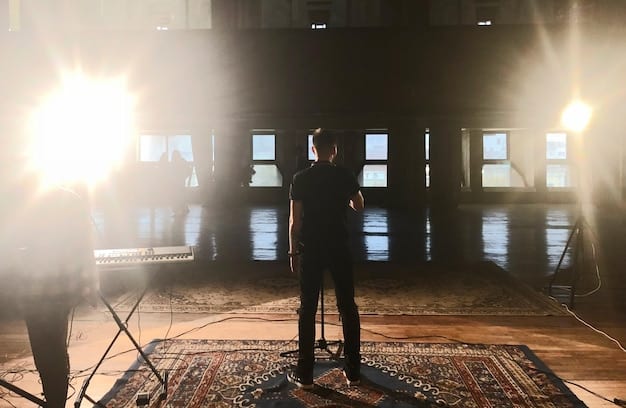 A wide shot of a stage set during a performance. The set is detailed and elaborate, creating a believable environment for the story to unfold. The lighting is used to create mood and focus attention on specific areas of the stage. This showcases the importance of set design and lighting.