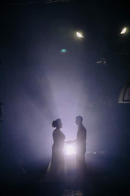 Actors on stage during a dramatic scene, with lighting creating strong shadows and a sound system subtly enhancing the emotional intensity of the performance. The focus is on the synergy between visual and auditory elements.