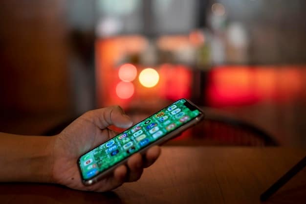 A close-up of a hand holding a smartphone displaying multiple streaming app icons, with a blurred background of a living room, symbolizing the digital convenience and choice of streaming services.